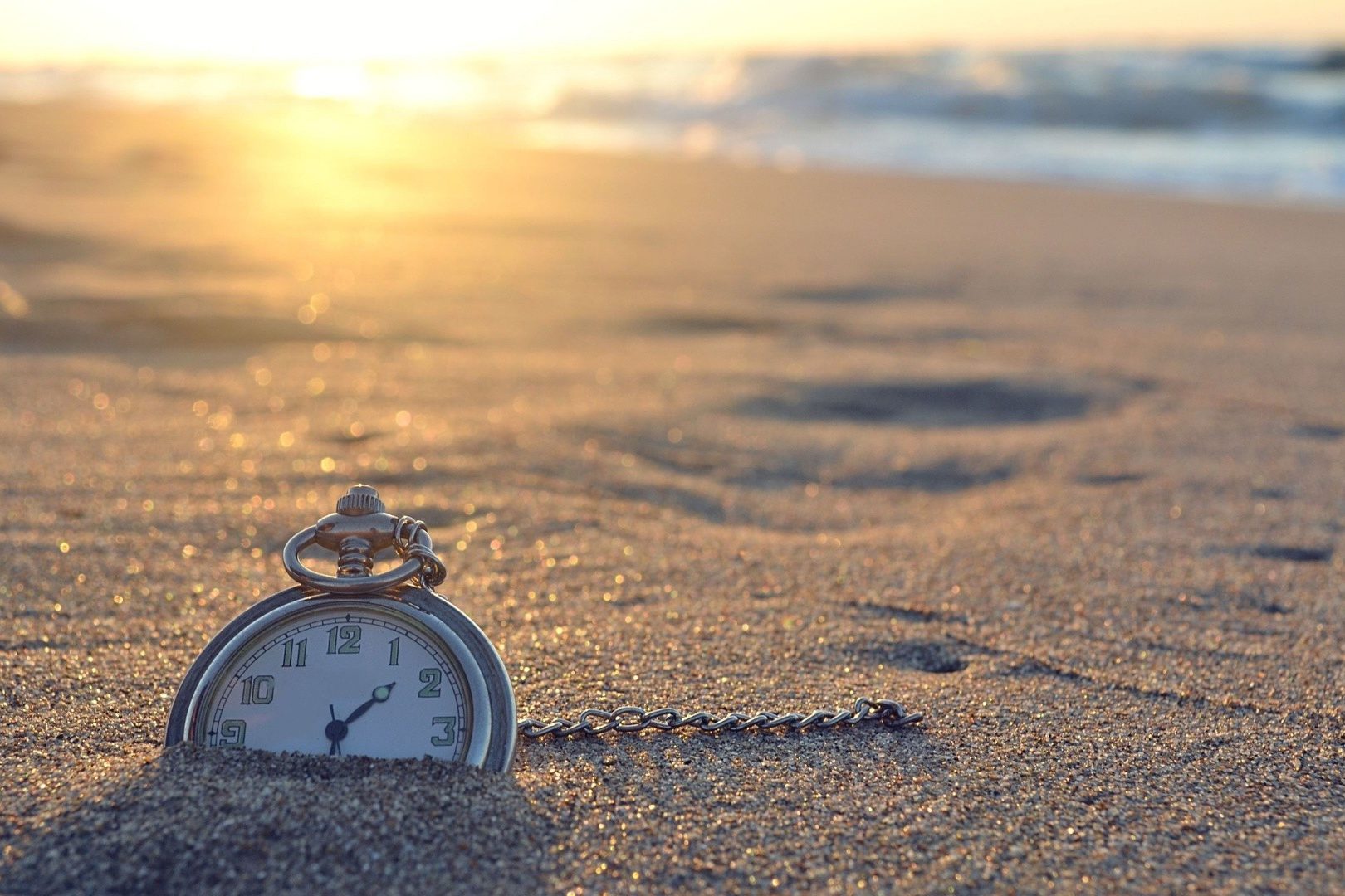 Creative_Wallpaper_Watch_on_a_chain_lying_in_the_sand_105895_